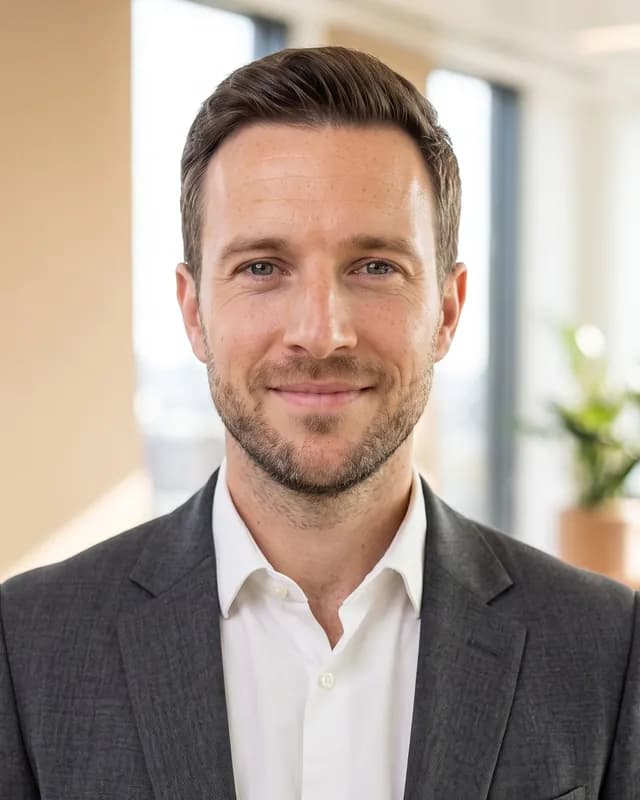 Example headshot in front of a blurred modern office